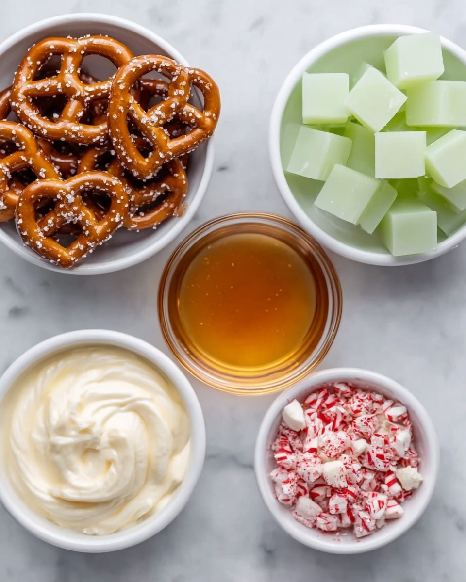 There are five small white bowls placed on a white marbled surface. The top left bowl holds dark brown pretzels sprinkled with coarse salt, shaped in twists. The top right bowl contains greenish-yellow translucent candy cubes. The center bowl holds large pale yellow squares of butter stacked unevenly. Below these, the bottom left bowl has thick white cream swirled smoothly, and the bottom right bowl contains small crushed peppermint pieces, white with red stripes. Photo taken with an iphone --ar 4:5 --v 7
