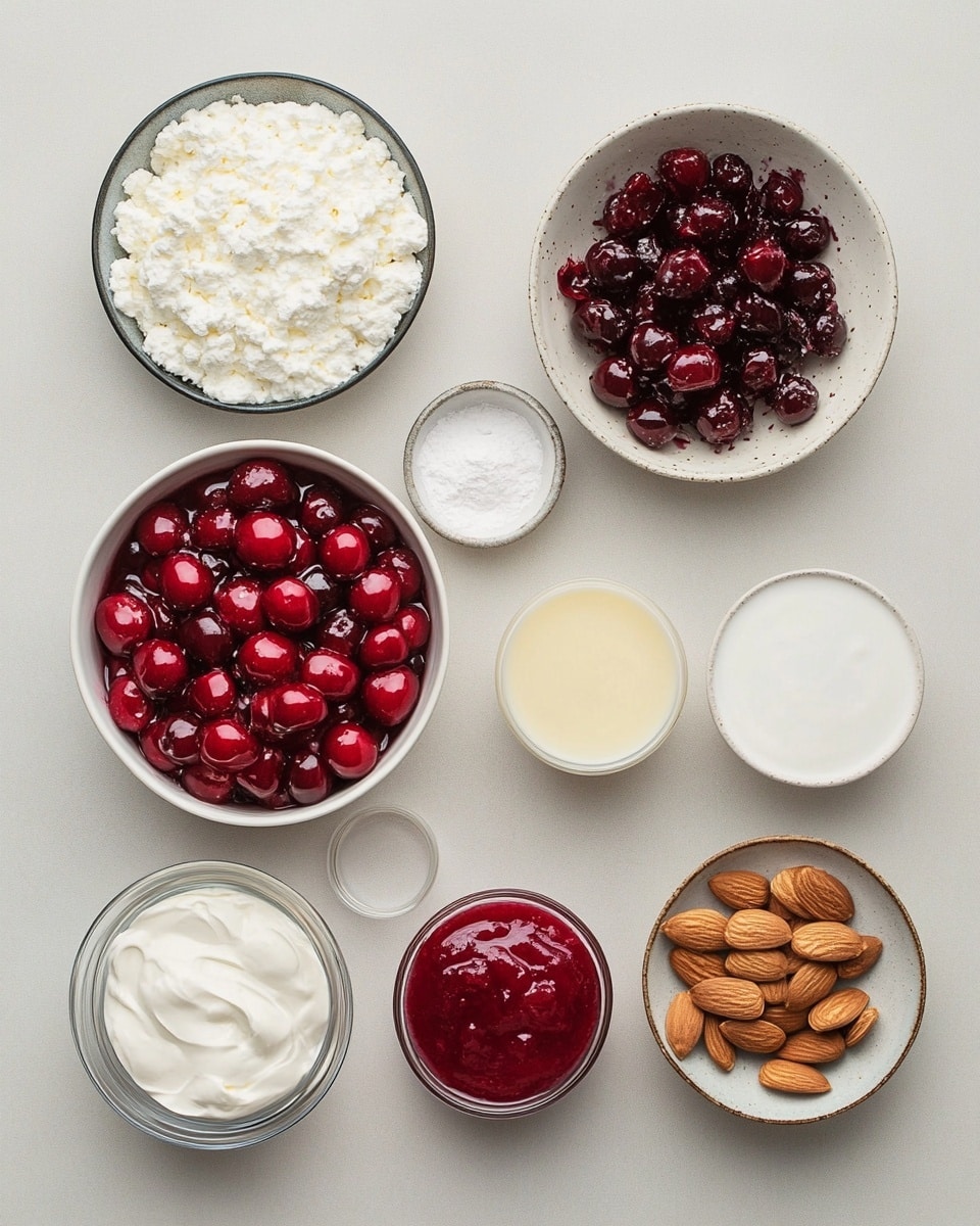 A white rectangular dish holds a layered strawberry dessert with a section removed, showing the inside which has four layers: a pale yellow sponge cake base, a red strawberry jelly layer with whole strawberries, a creamy light yellow custard layer, and a white whipped cream top layer swirled with red strawberry sauce. The top is decorated with sliced almonds scattered around, and fresh whole strawberries and green leaves are placed around the dish on a white marbled textured surface. Photo taken with an iphone --ar 4:5 --v 7
