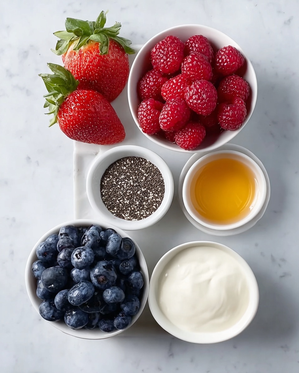 A clear glass filled with three visible layers starts with a base layer of bright red sliced strawberries at the bottom. The main middle layer is a thick, creamy purple chia pudding with small chia seeds spread evenly throughout, giving a textured look. On top, there are three thin, bright red strawberry slices arranged side-by-side, fanned out slightly, with a fresh green mint leaf placed in front of the strawberries. The glass sits on a white marbled surface with a slightly blurred second glass of the same pudding and a white plate holding whole strawberries in the background. A silver spoon lies diagonally near the glass. Photo taken with an iphone --ar 4:5 --v 7