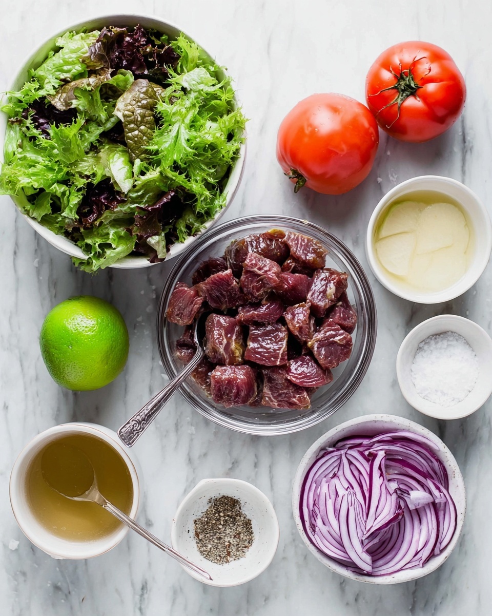 The image shows a white marbled surface with several ingredients arranged neatly. At the top left, there is a white bowl filled with fresh mixed green leafy lettuce, showing various shades of green and some dark purple. To its right, two whole bright red tomatoes sit close together. Below the tomatoes is a clear glass bowl holding marinated raw beef chunks, dark red with some marinade coating and a metal spoon inside. Below the bowl, to the left, lies a whole bright green lime. Next to it on the right is a small white cup filled with a light golden liquid, and beside this is a small round bowl with salt and black pepper mixed, the salt white and pepper in dark specks. At the bottom right, a white bowl holds sliced red onions, showing thin, curved purple rings. To the top right side, there is a small white bowl with a pale yellow liquid and a very small plate of white granulated salt. Everything is placed on the even-textured white marble background. photo taken with an iphone --ar 4:5 --v 7